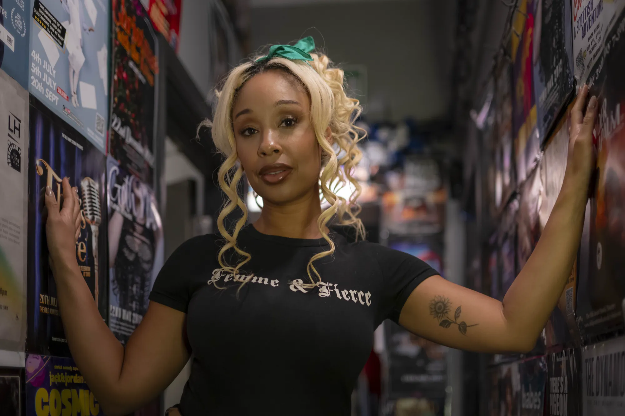 A dancer in a Femme & Fierce t-shirt in the poster-lined corridor