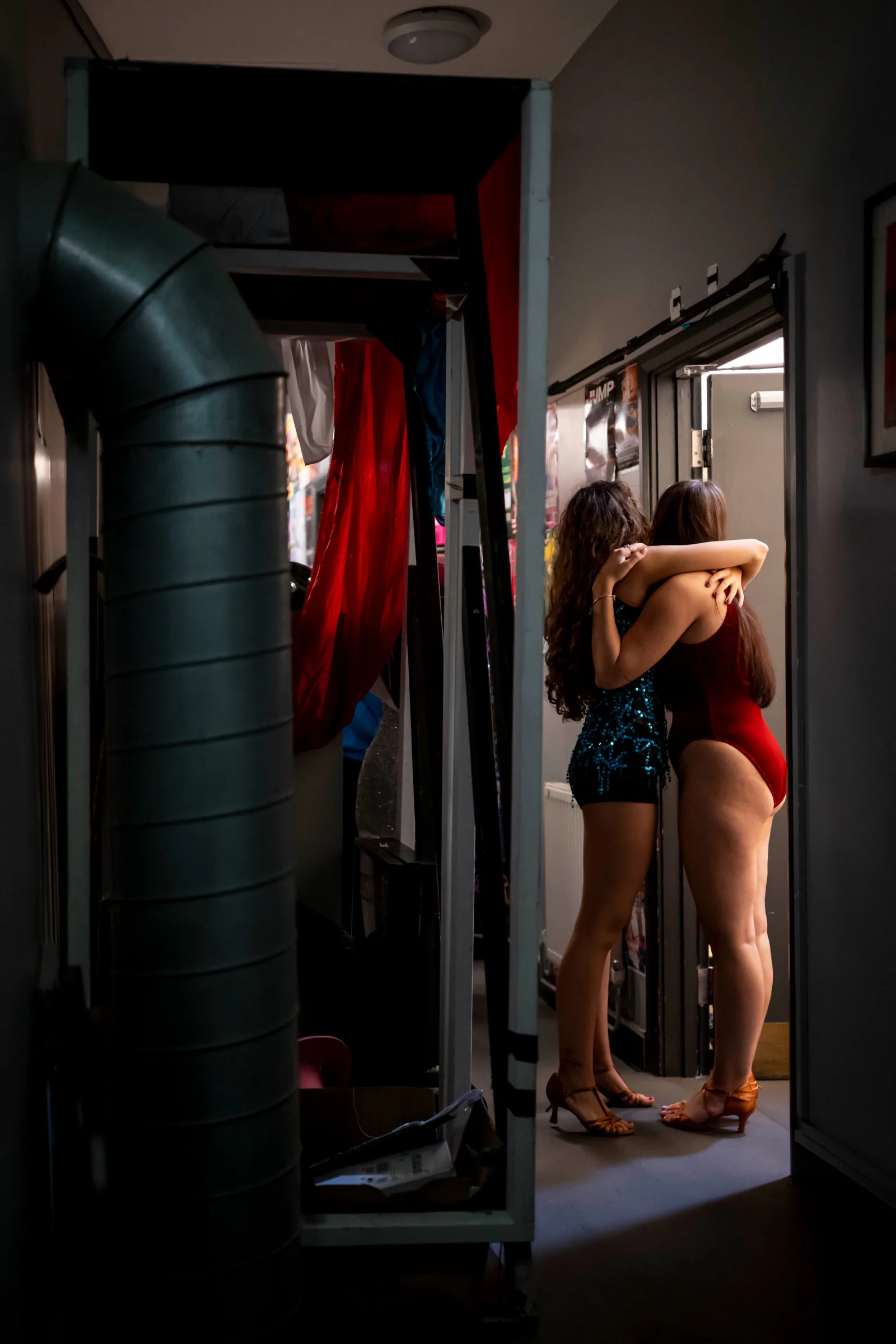 Two dancers embracing in the narrow corridor by the stage door